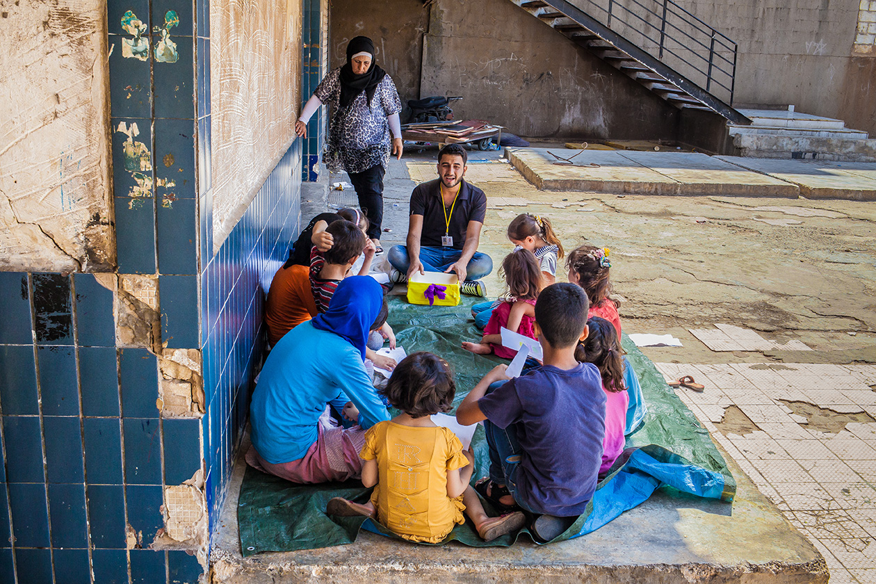 Overage children for their grade participating in an SEL activity with younger refugee children in Lebanon.