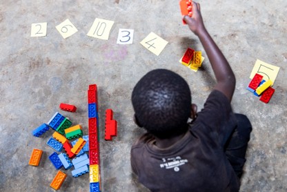 Child practicing counting using LEGO Six Bricks, Uganda, 2025