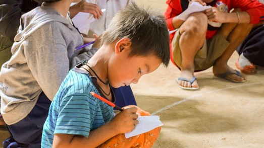 Child writing on a piece of paper | Credit: Right To Play&nbsp;