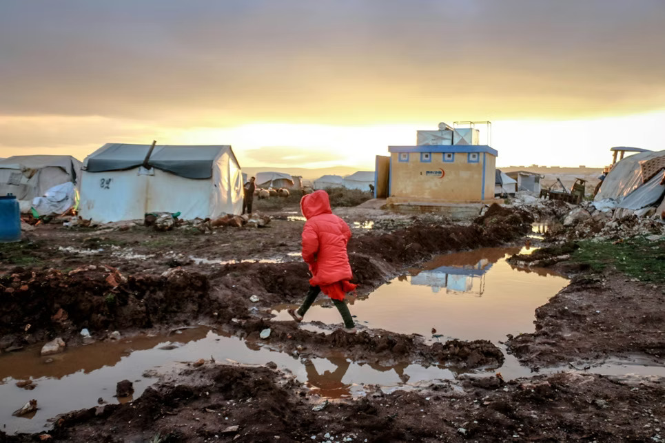 Young girl walking to school through flooded area